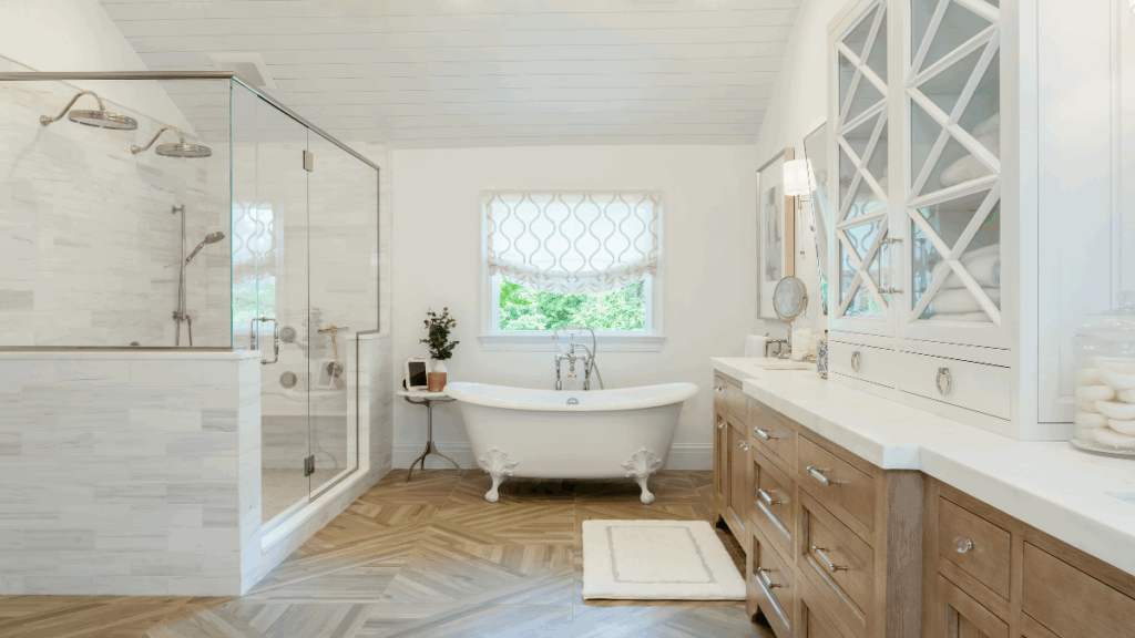Spa-inspired bathroom retreat featuring clawfoot tub, chevron flooring, and custom cabinetry by Melissa Sacco Interiors.